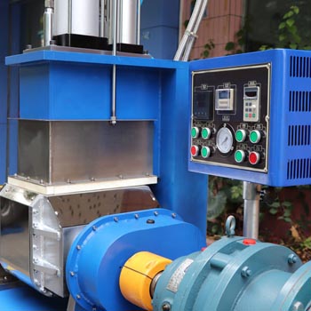 Laboratory kneader machine mixing thick rubber-like material in a stainless steel chamber
